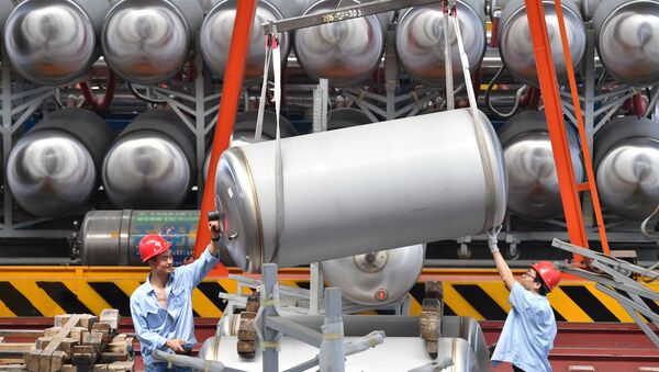 Employees work next to tanks for liquefied natural gas (LNG) at a factory in Xian, Shaanxi province, China June 3, 2019 - Sputnik International