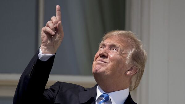 President Donald Trump points to the sun as he arrives to view the solar eclipse, Monday, Aug. 21, 2017, at the White House in Washington. - Sputnik International