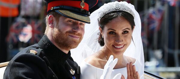 Britain's Prince Harry, Duke of Sussex and his wife Meghan, Duchess of Sussex wave from the Ascot Landau Carriage during their carriage procession on the Long Walk as they head back towards Windsor Castle in Windsor, on May 19, 2018 after their wedding ceremony.  - Sputnik International