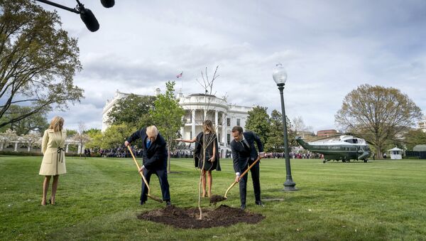 n this April 23, 2018, file photo, first lady Melania Trump, second from right, and Brigitte Macron, left, watch as President Donald Trump and French President Emmanuel Macron participate in a tree planting ceremony on the South Lawn of the White House in Washington - Sputnik International