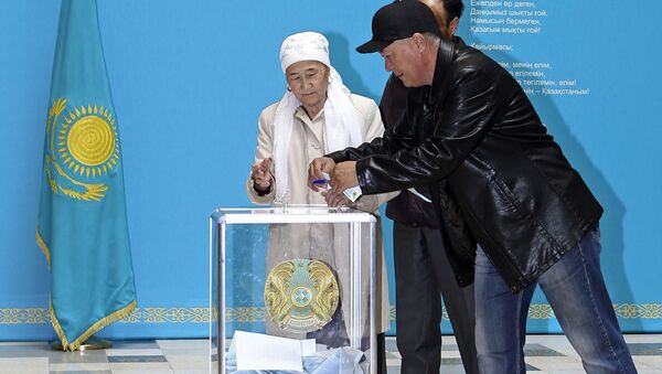 A member of an election commission helps an elderly Kazakh woman to cast her ballot at a polling station in Astana - Sputnik International