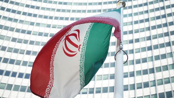 An Iranian flag waves in a wind outside the Vienna International Centre hosting the United Nations (UN) headquarters and the International Atomic Energy Agency (IAEA) as the socalled EU 5+1 talks with Iran take place in Vienna, on July 3, 2014 - Sputnik International