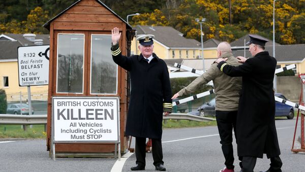 Two protesters dressed as border guards 'search' another protester in a stunt during a protest against any border between Ireland and Northern Ireland because of Brexit gather at the Carrickcarnan border between Newry in Norther Ireland and Dundalk in the Irish Republic on March 30, 2019 - Sputnik International