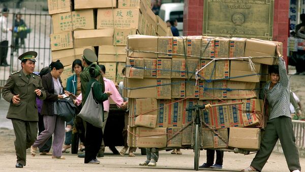 A Vietnamese border patrol guard checks Chinese goods arriving at the Tan Thanh border checkpoint with China in Lang Son, 165 kilometers (100 miles) northeast of Hanoi, on Monday, Feb. 25, 2002 - Sputnik International