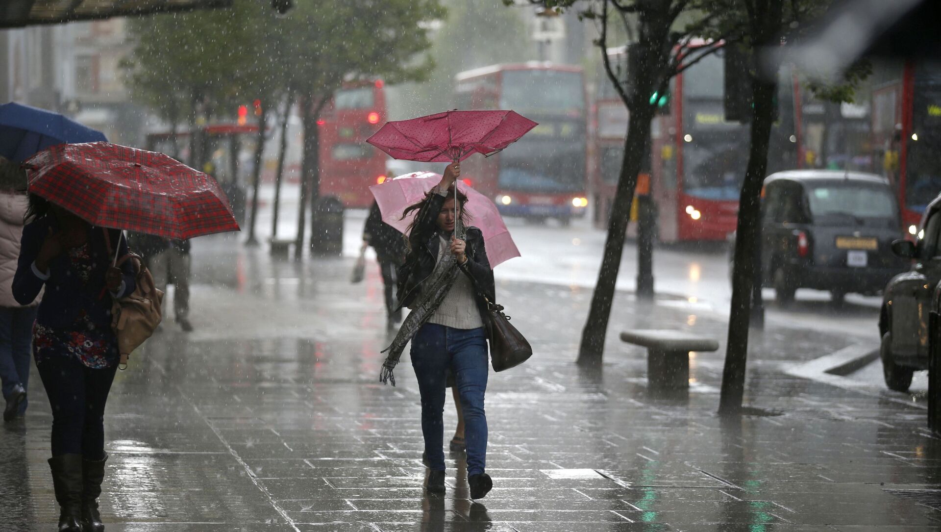 A woman's umbrella blown inside-out as she walks through a heavy rain shower on Oxford Street in London (File) - Sputnik International, 1920, 26.07.2021