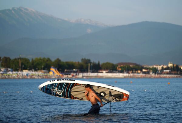 A man with a surf board in Sochi, Russia. - Sputnik International