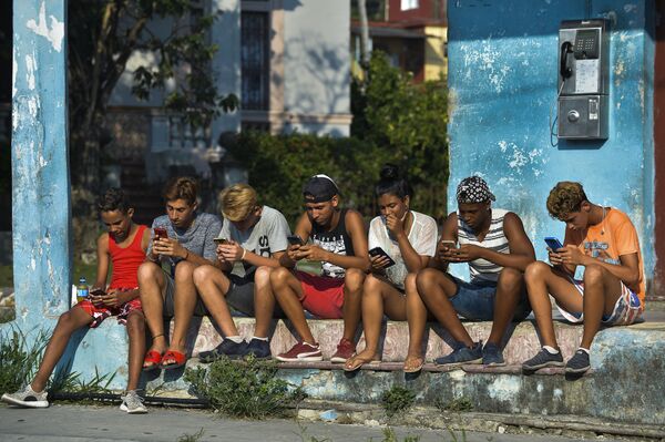 Young Cubans connect to internet from their mobile phone in Havana, on June 6, 2019. - Cubans do not hide their frustration six months after the arrival of mobile internet to the island as the connectivity is too expensive, slow and censored by the government.  - Sputnik International