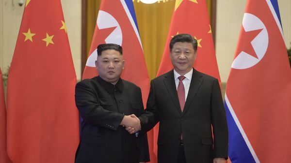 In this Tuesday, Jan. 8, 2019, photo released by China's Xinhua News Agency, North Korean leader Kim Jong Un, left, and Chinese President Xi Jinping shake hands as they pose for a photo before talks at the Great Hall of the People in Beijing - Sputnik International