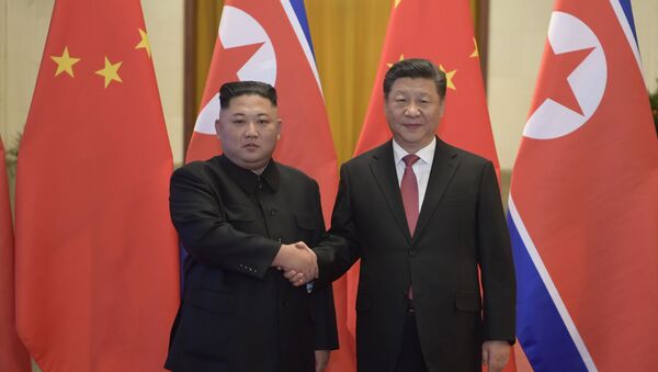 In this Tuesday, Jan. 8, 2019, photo released by China's Xinhua News Agency, North Korean leader Kim Jong Un, left, and Chinese President Xi Jinping shake hands as they pose for a photo before talks at the Great Hall of the People in Beijing - Sputnik International