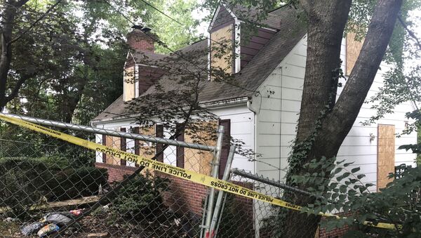In this Aug. 18, 2018, photo, police tape surrounds the house where Askia Khafra died in a fire while digging underground tunnels for a secretive campaign to build a nuclear bunker in Bethesda, Md. Daniel Beckwitt, a stock trader who lived alone in the house, is charged with second-degree murder and involuntary manslaughter in the Sept. 10, 2017, death of Askia Khafr - Sputnik International