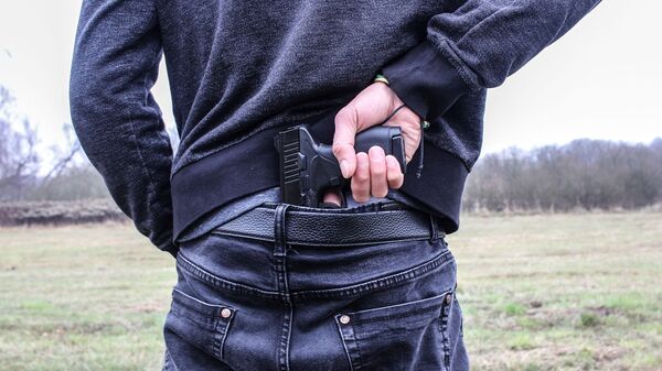 Man pulls handgun from waistband - Sputnik International