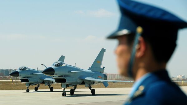 Chinese J-10 fighter jets pass an Air Force officer on the tarmac at the Yangcun Air Force base of the People's Liberation Army Air Force in Tianjin, home of the 24th Fighter Division, southeast of Beijing on 13 April 2010 - Sputnik International