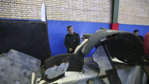 Head of the Revolutionary Guard's aerospace division Gen. Amir Ali Hajizadeh looks at debris from what the division describes as the U.S. drone which was shot down on Thursday, in Tehran, Iran, Friday, June 21, 2019 - Sputnik International