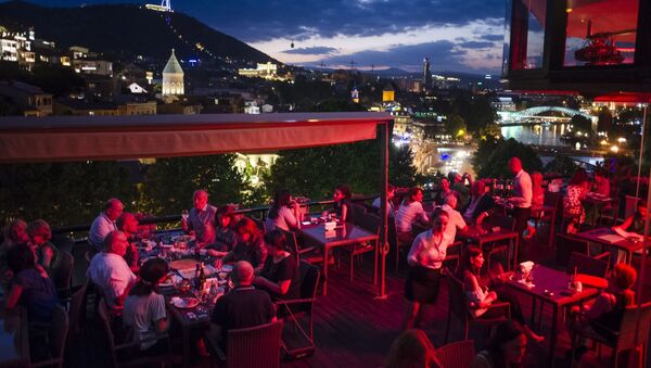 People rest at an open-air restaurant atop of a hill next to the Kura River in Tbilisi, Georgia - Sputnik International