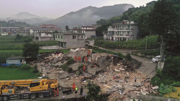 Rescue workers search for trapped people at a collapsed building after an earthquake in Shuanghe Town in Changning County of Yibin City - Sputnik International