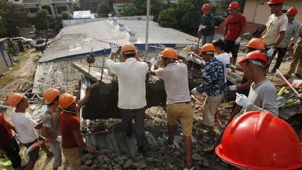Rescuers try to remove the rubble at the site of a collapsed building in Preah Sihanouk province, Cambodia - Sputnik International