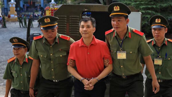 U.S. citizen Michael Nguyen is escorted by policemen before his trial at a court in Ho Chi Minh city, Vietnam June 24, 2019 - Sputnik International