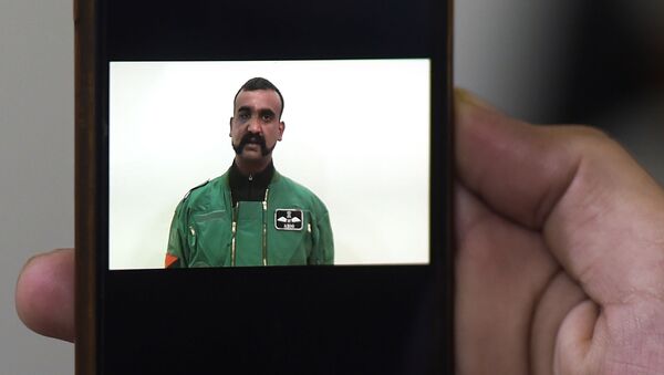 A Pakistani man watches the latest video statement released by Pakistan's military authorities of the Indian Wing Commander pilot Abhinandan Varthaman on his smartphone in Islamabad on March 1, 2019. - An Indian pilot shot down in a dogfight with Pakistani aircraft returned to India on March 1, after being freed in what Islamabad called a peace gesture following the two countries' biggest standoff in years. (Photo by AAMIR QURESHI / AFP) - Sputnik International