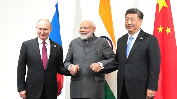 Russian President Vladimir Putin, India's Prime Minister Narendra Modi and Chinese President Xi Jinping pose for a photo during a meeting on the sidelines of the Group of 20 (G20) leaders summit in Osaka, Japan - Sputnik International