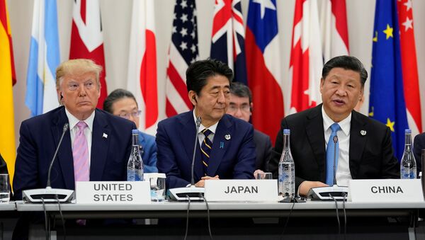 Japan's Prime Minister Shinzo Abe is flanked by U.S. President Donald Trump and China's President Xi Jinping during a meeting at the G20 leaders summit in Osaka, Japan, June 28, 2019 - Sputnik International