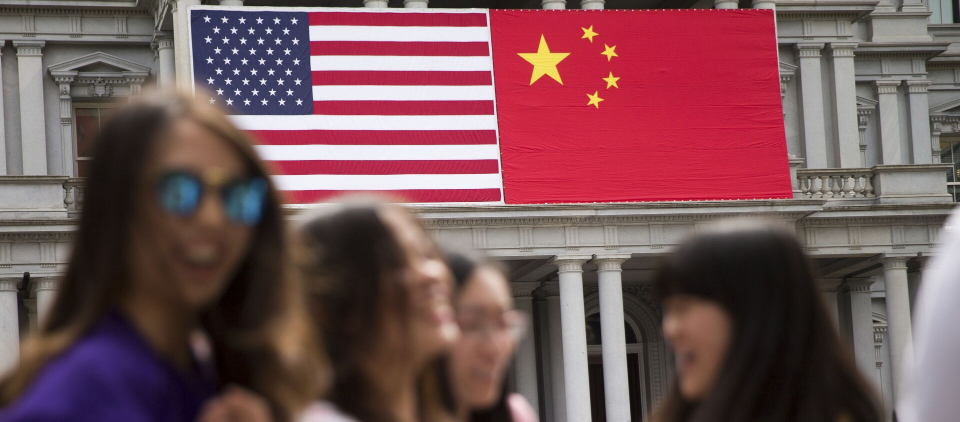 In this Thursday, Sept. 24, 2015, photo, China's flag is displayed next to the American flag on the side of the Old Executive Office Building on the White House complex in Washington, the day before a state visit by Chinese President Xi Jinping - Sputnik International, 1920, 29.12.2019