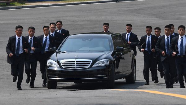 North Korean bodyguards jog next to a car carrying North Korea's leader Kim Jong Un returning to the North for a lunch break after a morning session of the inter-Korean summit at the truce village of Panmunjom on April 27, 2018 - Sputnik International