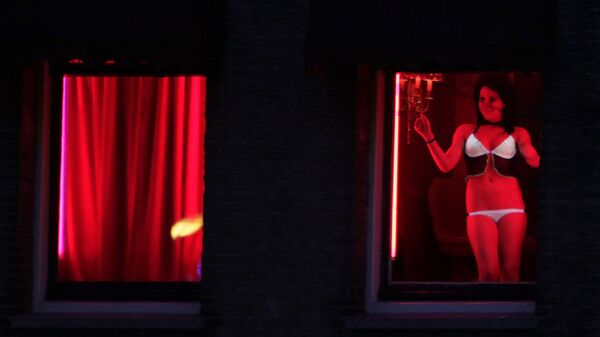 In this photo taken Monday Jan. 10, 2011 a prostitute advertises her wares behind red-lit windows in Amsterdam, Netherlands - Sputnik International