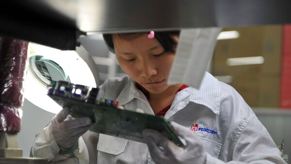A worker inspects a motherboard on a factory line at the Foxconn plant in Shenzen on 26 May 2010 - Sputnik International