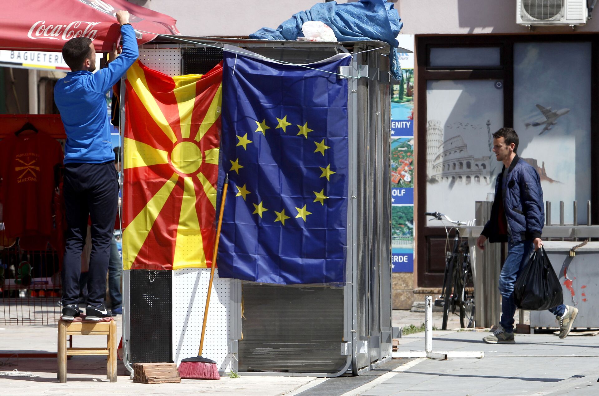 A street vendor fixes a North Macedonia flag next to an EU flag in a street in Skopje - Sputnik International, 1920, 07.09.2021