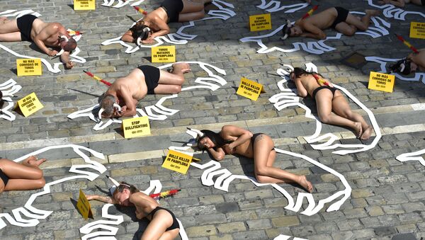 Pro-animal rights activists lie on the ground during a protest against bullfighting and bull-running called by the People for the Ethical Treatment of Animals (PETA) pro-animal group on the eve of the San Fermin festivities in the Northern Spanish city of Pamplona on July 5, 2019 - Sputnik International