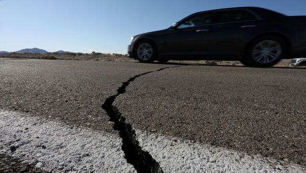 A car passes over a fissure that opened on a highway during a powerful earthquake that struck Southern California, near the city of Ridgecrest, California, U.S., July 4, 2019. - Sputnik International