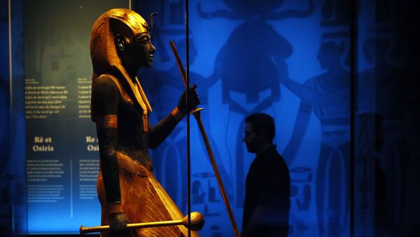 A visitor walks by a wooden guardian statue of the Ka of the king wearing the Names Headcloth displayed as part of 'Tutankhamun, the treasure of the Pharaoh', an exhibition in partnership with the Grand Egyptian Museum at the Grande Halle of La Villette in Paris, France, Thursday, March 21, 2019.  - Sputnik International