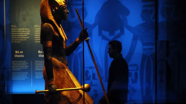 A visitor walks by a wooden guardian statue of the Ka of the king wearing the Names Headcloth displayed as part of 'Tutankhamun, the treasure of the Pharaoh', an exhibition in partnership with the Grand Egyptian Museum at the Grande Halle of La Villette in Paris, France, Thursday, March 21, 2019.  - Sputnik International