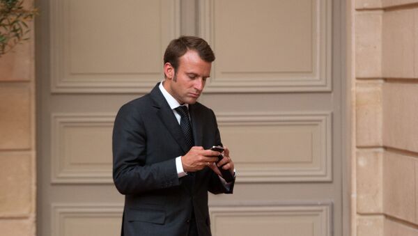 Emmanuel Macron, looks at his phone - Sputnik International
