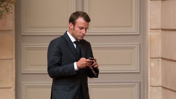 Emmanuel Macron, looks at his phone - Sputnik International