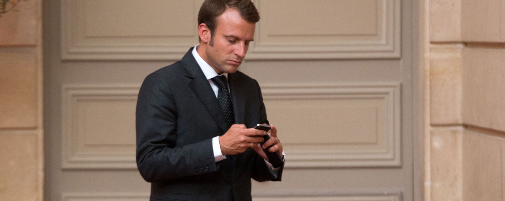 Emmanuel Macron, looks at his phone - Sputnik International, 1920, 30.08.2024