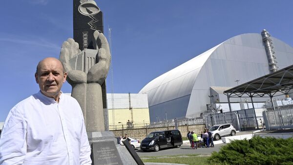 French Foreign Minister Jean-Yves Le Drian stands next to the monument in memory of the victims of the Chernobyl nuclear disaster at the New Safe Confinement (NSC) movable enclosure at the nuclear power plant in Chernobyl, Ukraine, Saturday, June 1, 2019. - Sputnik International