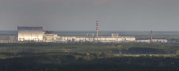 An aerial view of the Chernobyl nuclear power plant and a new shelter, left, installed over the exploded reactor at the Chernobyl nuclear plant, in Chernobyl, Ukraine, Thursday, April 26, 2018. - Sputnik International