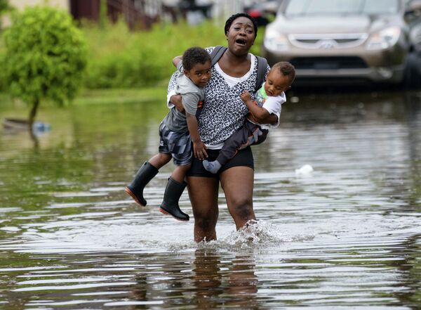 A woman carries children on Belfast Street in New Orleans during flooding from a storm in the Gulf Mexico that dumped lots of rain Wednesday, July 10, 2019. - Sputnik International