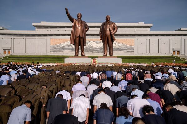 People bow before the statues of the late North Korean leaders Kim Il Sung and Kim Jong Il as the country marks the 25th death anniversary of Kim Il Sung, at Mansu Hill in Pyongyang on July 8, 2019. - Sputnik International