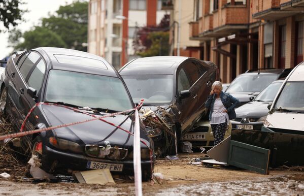 A woman speaks on the phone next to damaged cars after heavy rainfall in Tafalla, Spain, July 9, 2019.  - Sputnik International