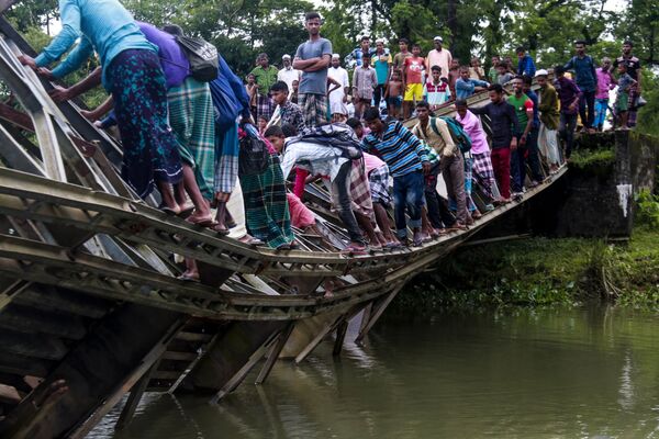 Bangladeshi pedestrians cross a broken bailey bridge in Sylhet on July 7, 2019. - Sputnik International
