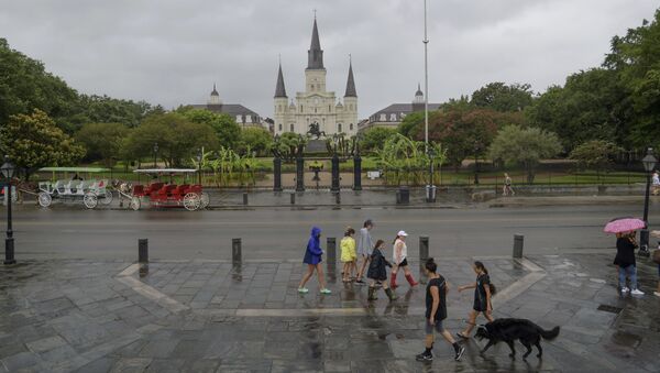 People walk past Jackson Square and St. Louis Cathedral in the French Quarter before landfall of Tropical Storm Barry from the Gulf of Mexico in New Orleans, La., Friday, July 12, 2019. - Sputnik International
