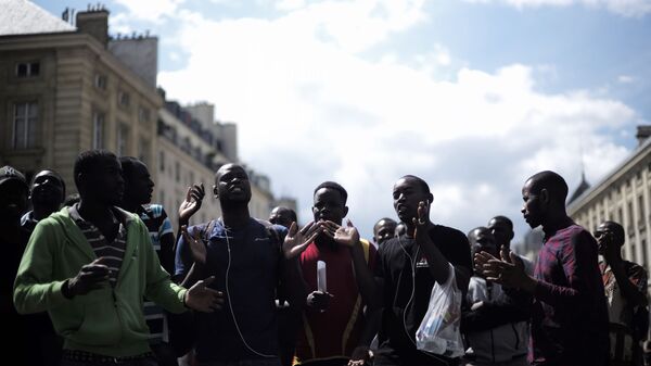 Migrants shout outside the Pantheon monument, where illustrious French figures are buried, in the Latin quarter of Paris, Friday, July 12, 2019. Dozens of migrants invaded the Pantheon. - Sputnik International