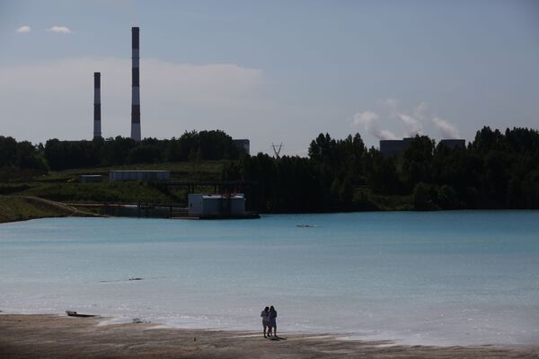 A couple walks by a Novosibirsk energy plant's ash dump site. - Sputnik International