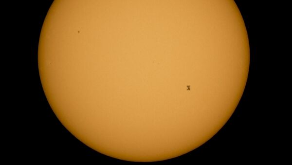In this photo provided by NASA, the International Space Station, with a crew of six onboard, is seen in silhouette as it travels across the face of the sun at roughly 5 mps, Sunday, Sept. 6, 2015, as seen from Shenandoah National Park, in Front Royal, Va - Sputnik International