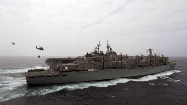 This US Navy photo obtained July 18, 2019 shows the amphibious assault ship USS Boxer (LHD 4), background, as it receives a vertical replenishment-at-sea from the fast combat support ship USNS Arctic (T-AOE 8) on July 14, 2019 in the Gulf. - Sputnik International
