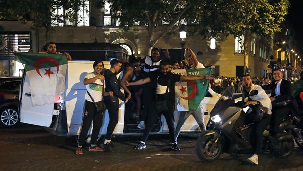 Algeria's supporters celebrate with the Algerian national flag in the Champs Elysee Avenue in Paris, after Algeria won 1-0 the 2019 Africa Cup of Nations (CAN) final football match between Algeria and Senegal, on July 19, 2019 - Sputnik International