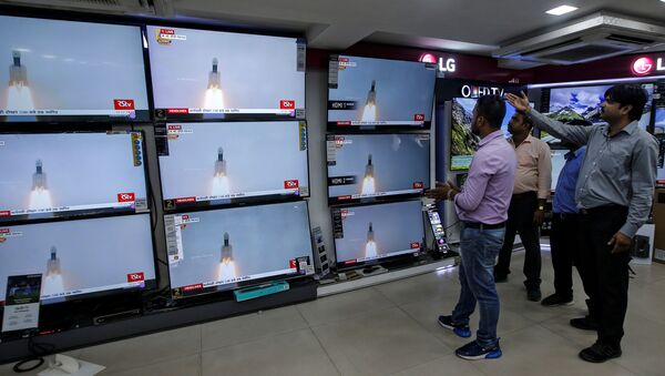 People celebrate as they watch a live broadcast of India's second lunar mission, Chandrayaan-2, inside an electronics showroom in Kolkata, India, July 22, 2019 - Sputnik International