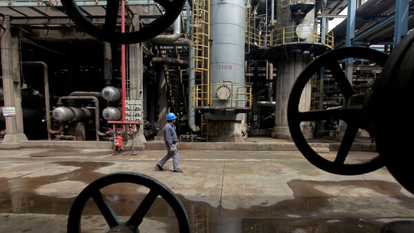 A worker walks past oil pipes at a refinery in Wuhan, Hubei province, China (File) - Sputnik International